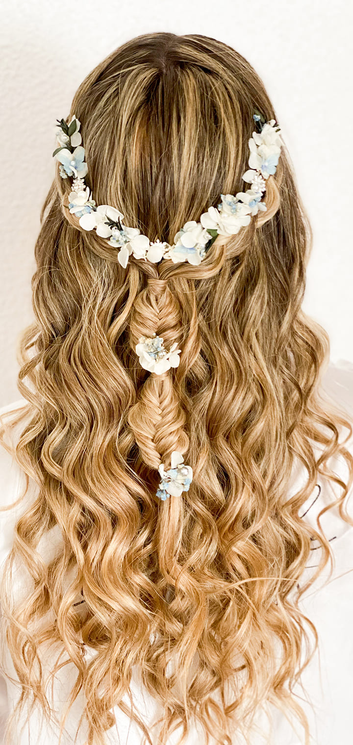 Peinado de novia semirrecogido con trenza y flores blancas