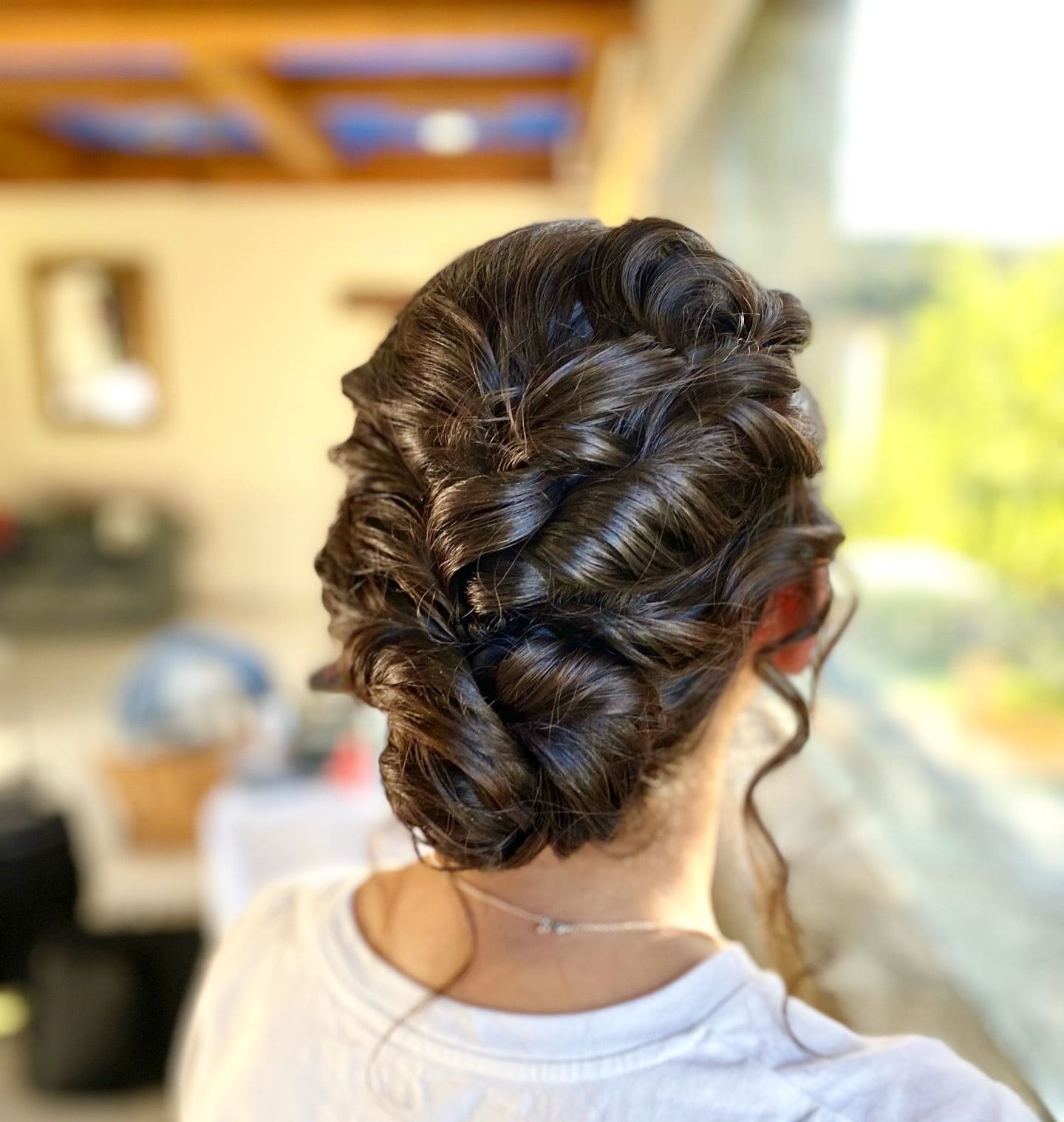 Recogido de novia elegante con moño bajo y mechones sueltos